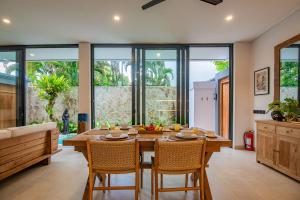 a dining room with a wooden table and chairs at Sister Suites in Seminyak