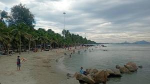 a group of people on a beach near the water at The Bliss House Bangsaen in Ban Laem Thaen