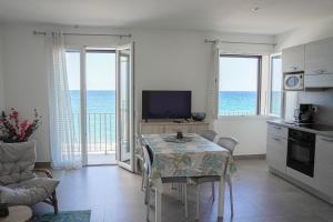 a kitchen and dining room with a table and a television at Résidence Pascal Paoli Fior di Mare in Moriani Plage