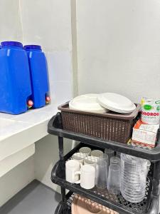 a shelf with plates and cups and dishes on it at Home stay near at Vluna Medical Center Kalayaan Avenue, Philippine Heart Center, East Avenue Medical Hospital, Quezon City in Manila