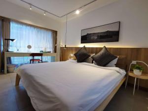Rúm í herbergi á Suzhou Xugusu B&B-Tangyinci Taohuawu Branch