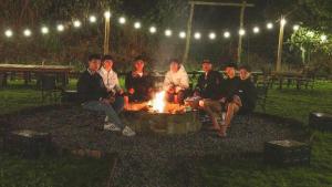 a group of people sitting around a fire at night at Thôn Yên Glamping in Xuan An +165 photos