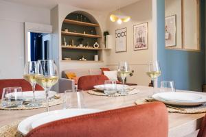 una mesa de comedor con copas de vino blanco en La Terrasse Saint-Gatien - PrestiPlace Collection, en Tours