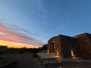 a stone house in the desert at sunset at Residence Dammusi Riah in Pantelleria