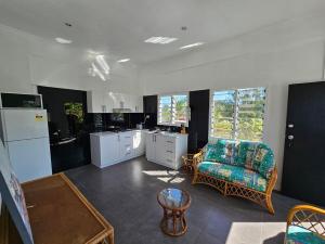 a kitchen with a couch and a chair in a room at Cosy one bedroom self contained apartment in Yandua