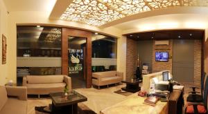 a lobby with a waiting area with couches and a tv at Hotel Kushala Executive Inn, Dombivali in Thane