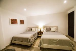 ein Zimmer mit zwei Betten und einem Tisch mit einer Lampe in der Unterkunft Apartment Buganvilia in San Miguel de Allende + 24 Fotos