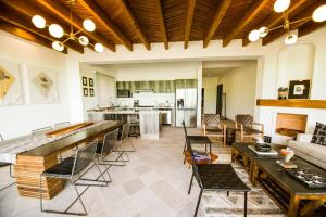 ein Wohnzimmer mit Tischen und Stühlen sowie eine Küche in der Unterkunft Apartment Buganvilia in San Miguel de Allende