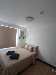 a bedroom with a large bed with pillows on it at REI365 Condotel in Davao City +28 photos