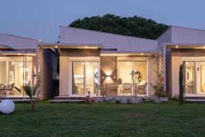 een huis met stoelen en tafels in een tuin bij Amadeus Golden Resort in Toroni