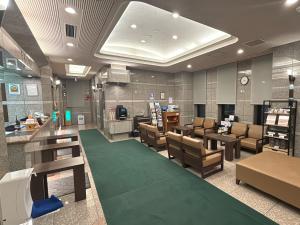 a waiting room at a store with a green carpet at Hotel Route-Inn Asahikawa Ekimae Ichijodori in Asahikawa