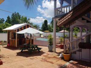 a patio with a picnic table and an umbrella at Almond tree villa in Ocho Rios