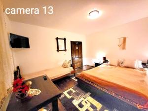 a bedroom with a bed and a table in a room at vila Dariana in Vatra Dornei