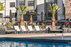 a pool with chairs and umbrellas next to a building at Gateway Getaway #102 condo in Hurricane