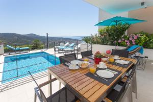 a table with plates of food on it next to a pool at Villa Lemon Tree in Vinišće +24 photos