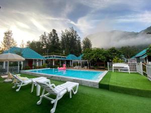 パクチョンにあるSuksaby khaoyai บ้านพักสุขสบาย เขาใหญ่のスイミングプールと家のあるリゾート