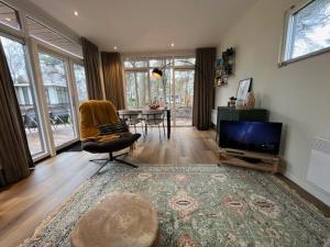 a living room with a television and a table at Villa Hutspot in Haarle