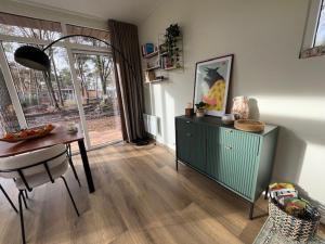 a living room with a table and a table and a dining room at Villa Hutspot in Haarle