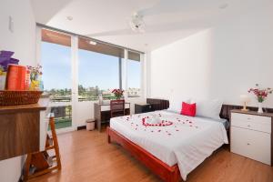 a bedroom with a bed with red flowers on it at Hestia HaMy Beach House in Hoi An