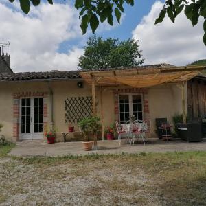 un patio exterior de una casa con sillas y mesas en Le Fournil de Douasse, en Puycalvel Lautrec