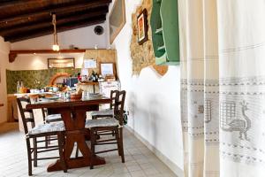 a kitchen with a wooden table and chairs at Fattoria La Traccia in Fertilia