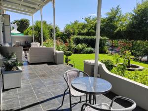 a patio with a table and chairs and a garden at La Damon 2 in Paarl