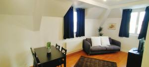 a living room with a couch and a table at Chez F&J in Elbeuf