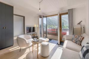 a living room with a couch and a table at Mont-Blanc View - Panoramic Balcony - Chamonix Centre in Chamonix