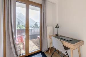 a desk and a window with a view of a balcony at Mont-Blanc View - Panoramic Balcony - Chamonix Centre in Chamonix
