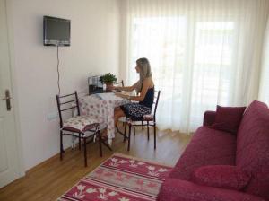 a woman sitting at a table in a living room at canakkale Merkez Sefer apartmanı 15 in Canakkale