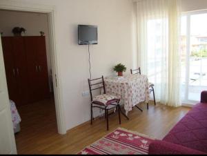 a living room with a table and chairs and a tv at canakkale Merkez Sefer apartmanı 15 in Canakkale