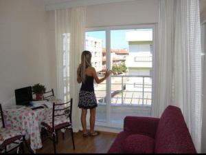 a woman looking out of a window at a balcony at canakkale Merkez Sefer apartmanı 15 in Canakkale