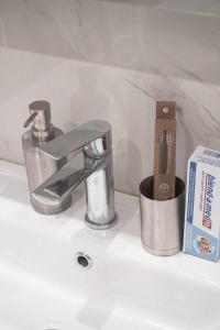 a sink with a faucet and a toothbrush holder at Glamour Apartment in Chişinău