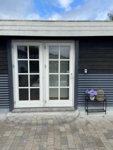 a sliding glass door on a house with flowers on a bench at Gæstehuset Husly in Haderup