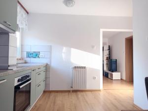 a kitchen with white cabinets and a staircase at Apartma Vodrice in Slap ob Idrijci +8 photos