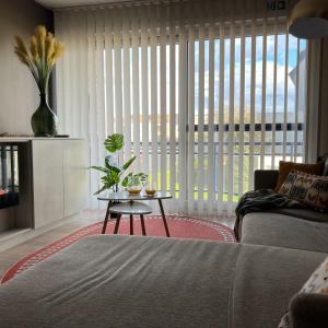 a living room with a couch and a table and a window at Duinhelm Vakantiestudio Mariakerke - A cosy place by the sea in Ostend