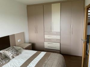 een slaapkamer met een bed en een grote witte kast bij Casa con vistas impresionantes in A Coruña