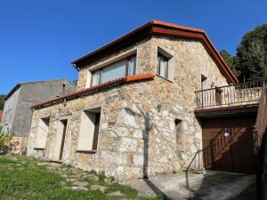 een stenen gebouw met een balkon erboven bij Casa con vistas impresionantes in A Coruña