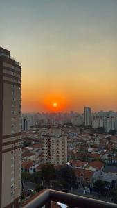 a city skyline with the sun setting in the distance at Essential 2U in Sao Paulo