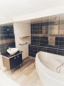 a bathroom with a tub and a sink at chalonnaise house 120m2 in Chalons en Champagne +8 photos
