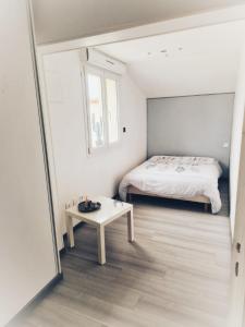 a small bedroom with a bed and a table at chalonnaise house 120m2 in Chalons en Champagne