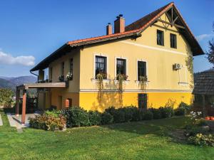 Lovrenc na PohorjuGeratičevo的黄色房子,窗户上放着花盒