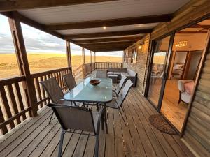 a wooden deck with a table and chairs on it at Rolling Hills Farmstead in Caledon