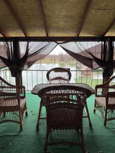 a table and chairs with a table and a fence at Отель біля озера in Mukacheve