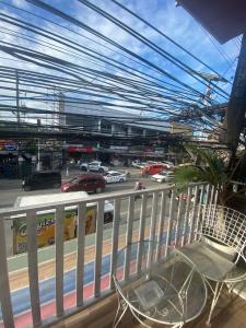 a chair sitting on a balcony with a view of a street at TONCIL HOMESTAY - Bed and Bath near Anjo World in Minglanilla +7 photos