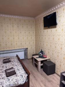 a room with a bed and a table and a television at Отель біля озера in Mukacheve