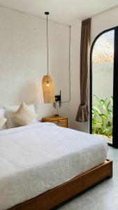 Un dormitorio con una cama blanca y una ventana. en Best Deals - New Fancy 2BR Private Pool Villa, en Uluwatu