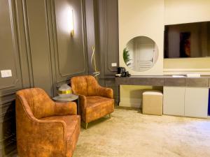 a living room with two chairs and a table and a mirror at Eastern Al Montazah Hotel in Alexandria