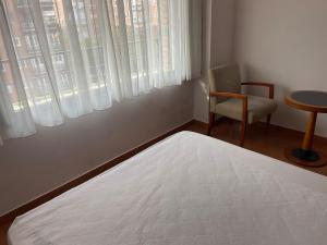 マドリードにあるChamartin St calle Mauricio Legendreのベッドと椅子と窓のある寝室