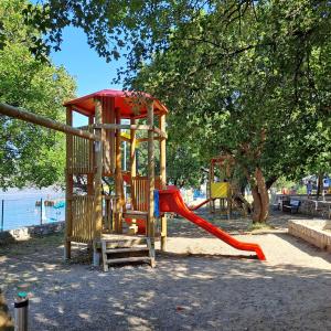 a playground with a slide in a park at Mobile Home Livanda in Klenovica